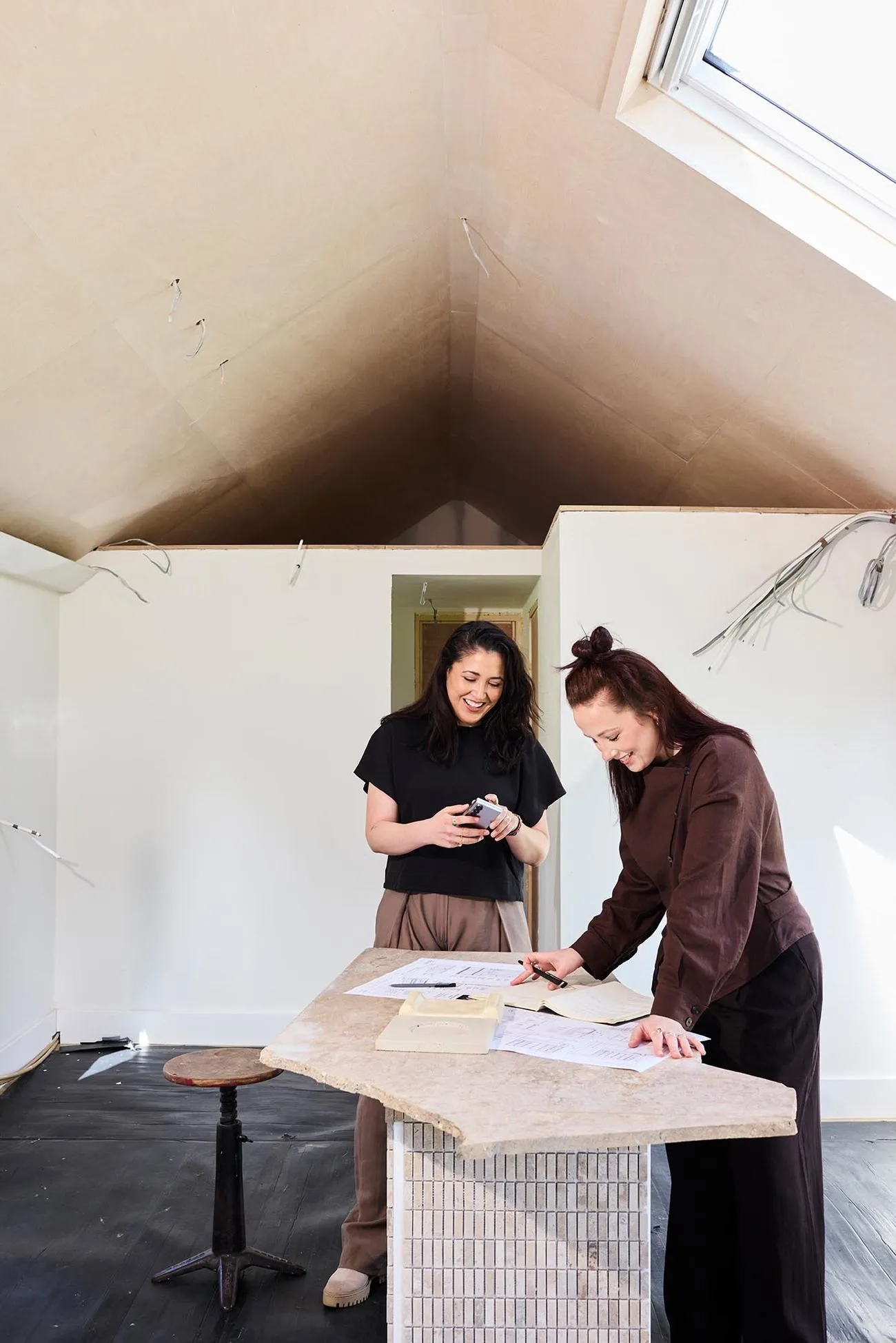 MJ and Clíodhna reviewing plans together inside the passive house studio build