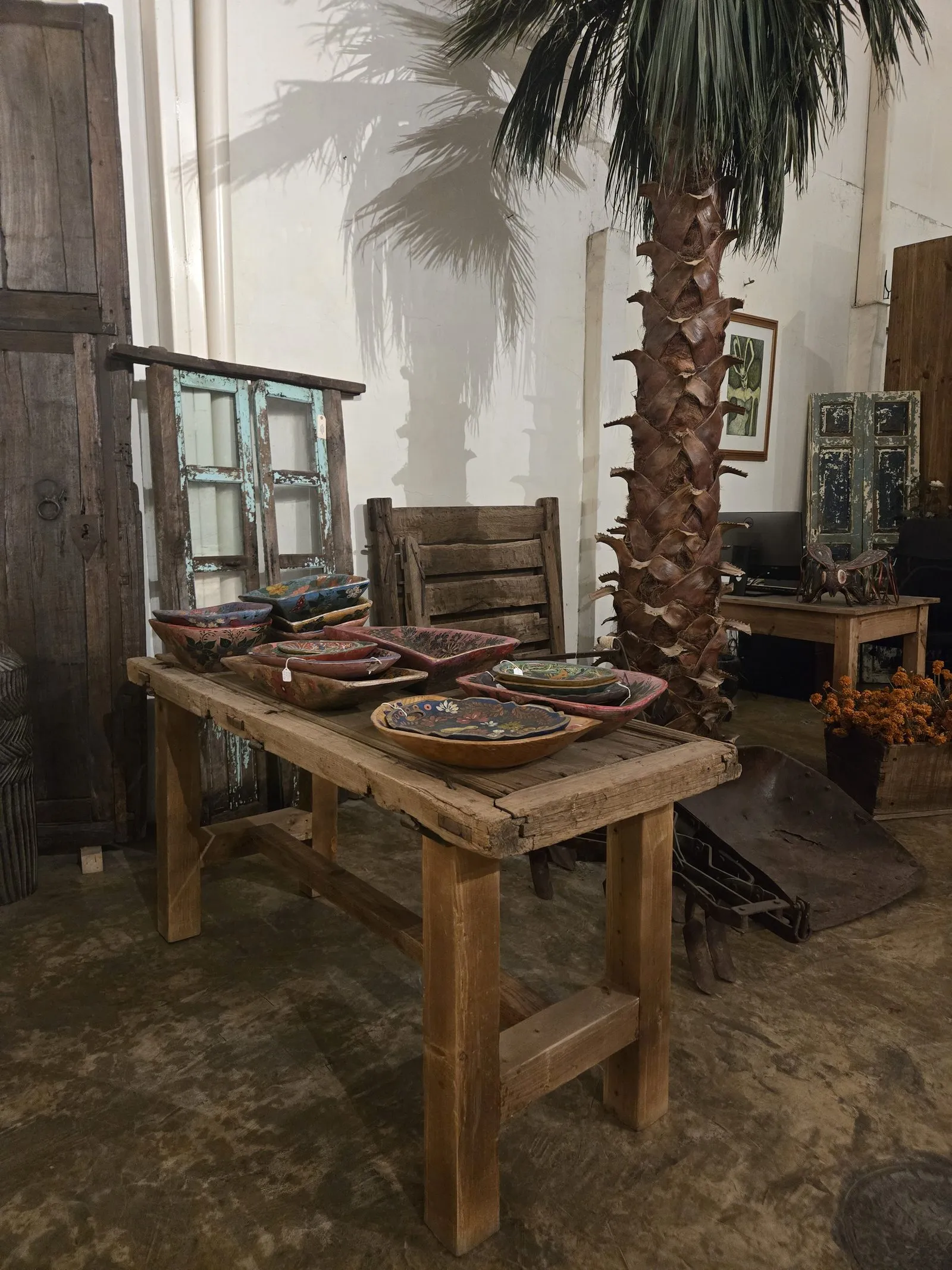 Reclaimed wood table and hand-painted bowls in a Mexican design showroom