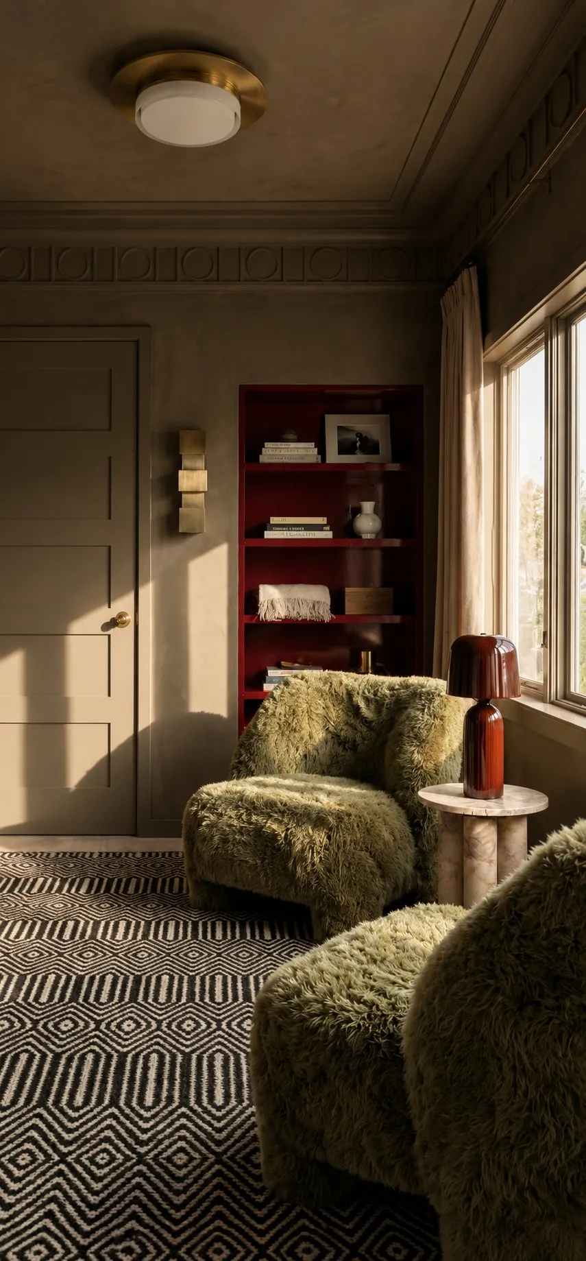 Snug reading corner with olive shearling chairs, a patterned rug and the red lacquered shelving