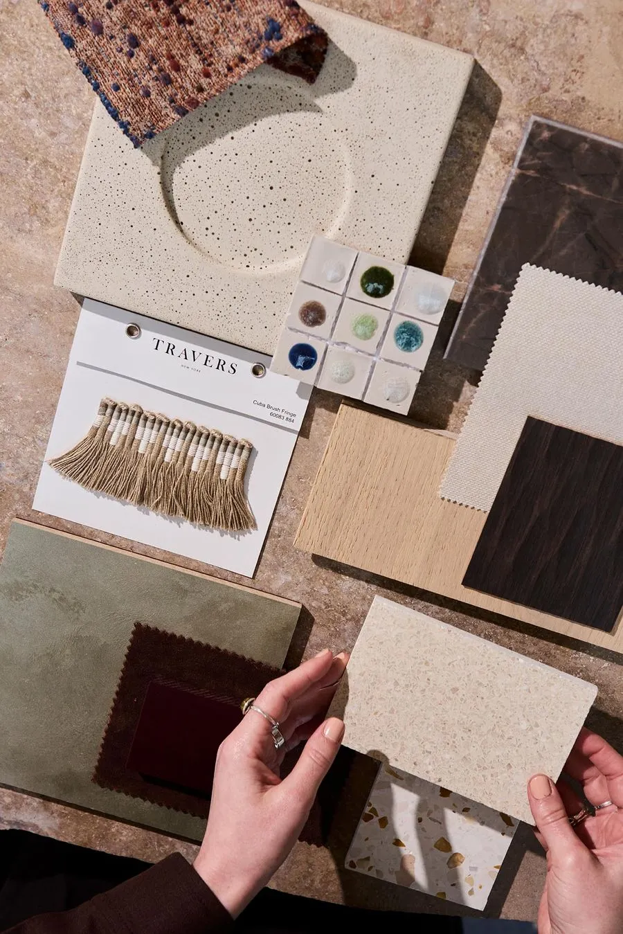 Fabric and tile samples being reviewed by hand